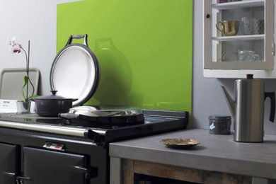 Cette image montre une cuisine design avec une crédence verte et une crédence en feuille de verre.