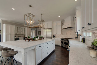 Example of a large transitional l-shaped dark wood floor and brown floor open concept kitchen design in Nashville with a farmhouse sink, shaker cabinets, white cabinets, marble countertops, white backsplash, brick backsplash, stainless steel appliances, an island and white countertops