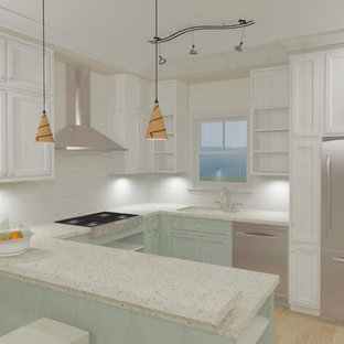 This is an example of a mid-sized beach style u-shaped open plan kitchen in Charleston with an undermount sink, recessed-panel cabinets, turquoise cabinets, recycled glass benchtops, white splashback, subway tile splashback, stainless steel appliances, medium hardwood floors and a peninsula.