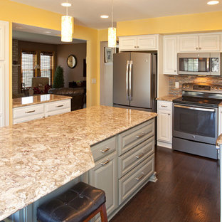 Inspiration for a mid-sized transitional l-shaped eat-in kitchen in Minneapolis with an undermount sink, raised-panel cabinets, green cabinets, quartz benchtops, multi-coloured splashback, metal splashback, stainless steel appliances, medium hardwood floors and multiple islands.