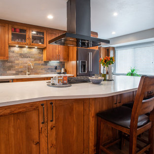 Design ideas for a large country l-shaped eat-in kitchen in Denver with an undermount sink, shaker cabinets, brown cabinets, quartz benchtops, multi-coloured splashback, slate splashback, stainless steel appliances, medium hardwood floors, with island, brown floor and white benchtop.