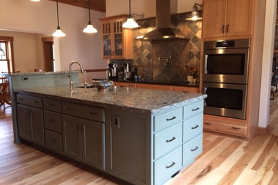 Example of a mid-sized arts and crafts galley light wood floor and beige floor eat-in kitchen design in Other with an undermount sink, shaker cabinets, light wood cabinets, granite countertops, multicolored backsplash, stone tile backsplash, stainless steel appliances and an island