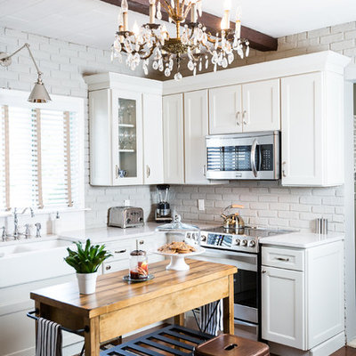 Enclosed kitchen - large rustic l-shaped dark wood floor and brown floor enclosed kitchen idea in Other with a farmhouse sink, white cabinets, stainless steel appliances, an island, recessed-panel cabinets, quartzite countertops, gray backsplash and subway tile backsplash