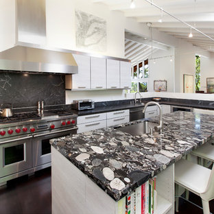 Photo of a large contemporary u-shaped kitchen in San Francisco with flat-panel cabinets, grey cabinets, granite benchtops, black splashback, stone slab splashback, stainless steel appliances, dark hardwood floors, with island, black benchtop, an undermount sink and brown floor.