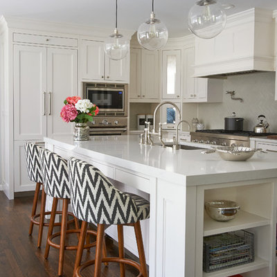 Inspiration for a mid-sized transitional l-shaped dark wood floor eat-in kitchen remodel in New York with shaker cabinets, white cabinets, quartz countertops, gray backsplash, ceramic backsplash, paneled appliances and an island