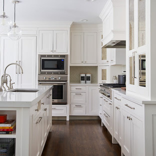 Mid-sized transitional eat-in kitchen remodeling - Eat-in kitchen - mid-sized transitional l-shaped dark wood floor eat-in kitchen idea in New York with a farmhouse sink, shaker cabinets, white cabinets, quartz countertops, gray backsplash, ceramic backsplash, paneled appliances and an island