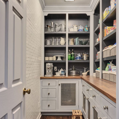 Kitchen pantry - traditional l-shaped dark wood floor and brown floor kitchen pantry idea in New York with recessed-panel cabinets, gray cabinets, wood countertops, no island and brown countertops