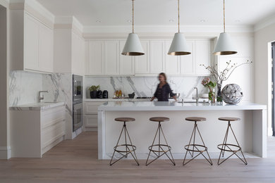 Design ideas for a contemporary l-shaped kitchen in San Francisco with a submerged sink, shaker cabinets, white cabinets, stainless steel appliances and marble splashback.