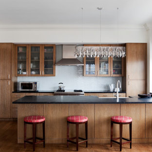 Mid-sized contemporary eat-in kitchen inspiration - Eat-in kitchen - mid-sized contemporary u-shaped medium tone wood floor eat-in kitchen idea in New York with a farmhouse sink, glass-front cabinets, medium tone wood cabinets and stainless steel appliances