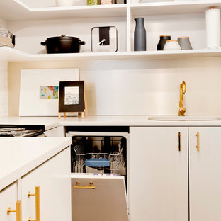 Photo of a small modern l-shaped open plan kitchen in New York with an undermount sink, open cabinets, white cabinets, quartz benchtops, white splashback, subway tile splashback, panelled appliances, light hardwood floors and no island.