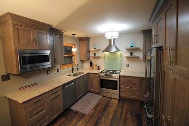 Example of a mid-sized classic u-shaped dark wood floor and brown floor eat-in kitchen design in Chicago with an undermount sink, recessed-panel cabinets, dark wood cabinets, granite countertops, stainless steel appliances, no island and beige countertops