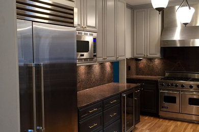 Example of a mid-sized classic u-shaped medium tone wood floor eat-in kitchen design in Chicago with raised-panel cabinets, gray cabinets, granite countertops and stainless steel appliances