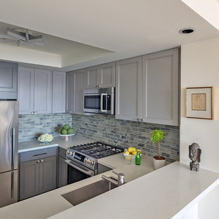 This is an example of a small contemporary u-shaped eat-in kitchen in San Francisco with an undermount sink, shaker cabinets, grey cabinets, quartz benchtops, multi-coloured splashback, glass tile splashback, stainless steel appliances, linoleum floors, no island, brown floor and white benchtop.