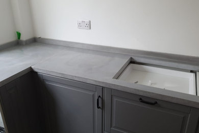 This is an example of a contemporary kitchen in Kent with concrete worktops, grey splashback, cement tile splashback and grey worktops.