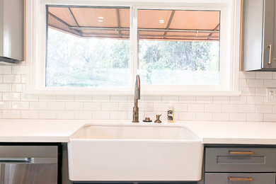 Inspiration for a mid-sized contemporary ceramic tile kitchen remodel in Los Angeles with a farmhouse sink, white backsplash, subway tile backsplash and white countertops