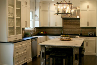 Mid-sized farmhouse l-shaped dark wood floor and brown floor eat-in kitchen photo in Birmingham with a farmhouse sink, shaker cabinets, white cabinets, soapstone countertops, brown backsplash, wood backsplash, stainless steel appliances and an island