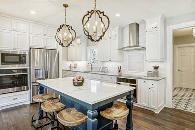 Inspiration for a large transitional l-shaped brown floor and medium tone wood floor eat-in kitchen remodel in Austin with an undermount sink, white cabinets, quartz countertops, white backsplash, stainless steel appliances, an island, recessed-panel cabinets, gray countertops and porcelain backsplash