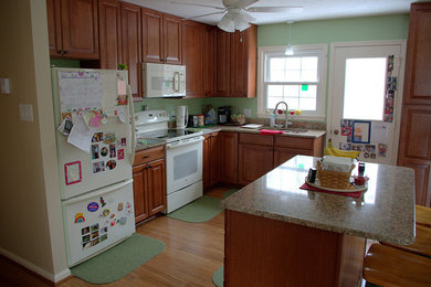 ワシントンD.C.にある中くらいなトラディショナルスタイルのおしゃれなキッチン (ダブルシンク、レイズドパネル扉のキャビネット、中間色木目調キャビネット、御影石カウンター、白い調理設備、無垢フローリング) の写真
