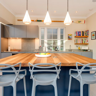 Design ideas for a contemporary single-wall kitchen in London with flat-panel cabinets, grey cabinets, wood worktops and an island.