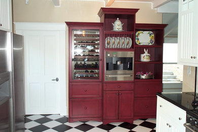 Exemple d'une cuisine américaine nature avec un placard avec porte à panneau encastré, des portes de placard rouges et un plan de travail en bois.