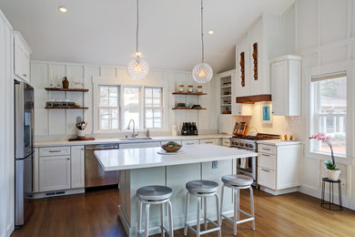 Mid-sized cottage u-shaped medium tone wood floor and yellow floor open concept kitchen photo in San Francisco with a single-bowl sink, shaker cabinets, white cabinets, quartz countertops, white backsplash, subway tile backsplash, stainless steel appliances and an island