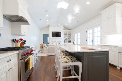 Bild på ett stort vintage kök, med en rustik diskho, luckor med upphöjd panel, vita skåp, vitt stänkskydd, stänkskydd i keramik, rostfria vitvaror, mörkt trägolv, en köksö och marmorbänkskiva