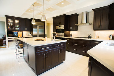 Large transitional l-shaped porcelain tile eat-in kitchen photo in Toronto with an undermount sink, shaker cabinets, dark wood cabinets, quartz countertops, white backsplash, porcelain backsplash, stainless steel appliances and an island