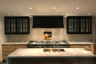 Gun blued steel vent hood and steel and glass cabinets with a nice La Cornue ran