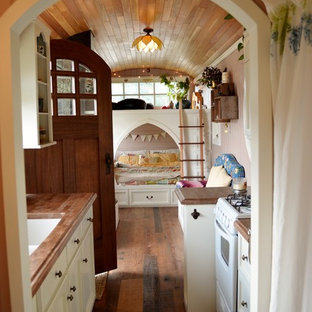 Design ideas for a small arts and crafts galley open plan kitchen in Seattle with an undermount sink, open cabinets, white cabinets, wood benchtops, coloured appliances, medium hardwood floors and no island.
