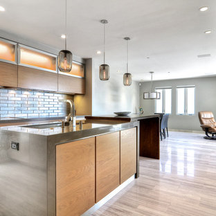 Photo of a large modern l-shaped open plan kitchen in San Francisco with an undermount sink, flat-panel cabinets, light wood cabinets, zinc benchtops, metallic splashback, metal splashback, stainless steel appliances, ceramic floors, with island and beige floor.