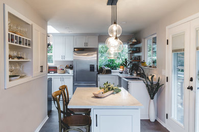 Inspiration for a small transitional l-shaped ceramic tile and gray floor eat-in kitchen remodel in Seattle with a farmhouse sink, shaker cabinets, white cabinets, quartz countertops, green backsplash, ceramic backsplash, stainless steel appliances, an island and white countertops
