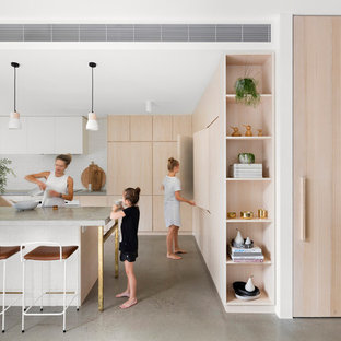 Inspiration for a scandinavian kitchen in Melbourne with flat-panel cabinets, light wood cabinets, concrete floors, grey floor and grey benchtop.