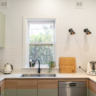 Photo of a mid-sized contemporary u-shaped eat-in kitchen in Newcastle - Maitland with flat-panel cabinets, green cabinets, quartz benchtops, white splashback, subway tile splashback, stainless steel appliances, a peninsula, white benchtop and a double-bowl sink.
