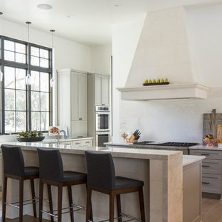 Idee per una cucina mediterranea di medie dimensioni con ante in stile shaker, ante grigie, paraspruzzi bianco, elettrodomestici da incasso, parquet chiaro, top in granito e paraspruzzi con piastrelle di vetro