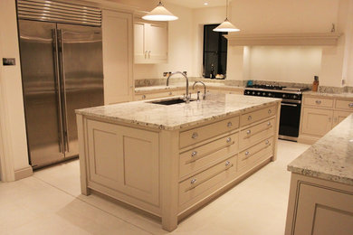 Photo of a traditional kitchen in London with stainless steel appliances and an island.