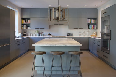 Design ideas for a medium sized contemporary u-shaped kitchen in London with flat-panel cabinets, blue cabinets, marble worktops, stainless steel appliances, lino flooring, an island and beige floors.