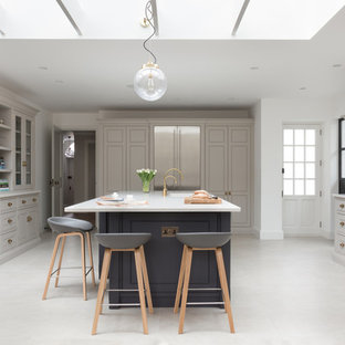 Photo of a medium sized classic kitchen in London with an island, grey cabinets, stainless steel appliances, grey floors and white worktops.