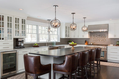 Eat-in kitchen - l-shaped eat-in kitchen idea in Manchester with shaker cabinets, white cabinets, marble countertops, gray backsplash, stainless steel appliances and an island