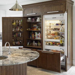 Design ideas for a traditional kitchen pantry in London with granite worktops, a submerged sink, shaker cabinets, dark wood cabinets, integrated appliances, an island, beige floors and limestone flooring.