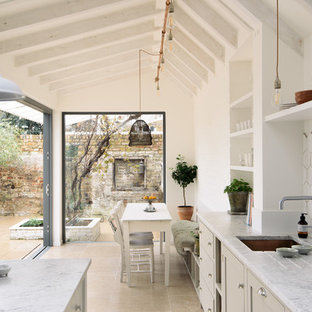Design ideas for a medium sized classic kitchen/diner with shaker cabinets, beige cabinets, marble worktops, white splashback, limestone flooring, beige floors, a submerged sink and white worktops.