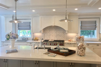Inspiration for a large coastal l-shaped open concept kitchen remodel in New York with an undermount sink, recessed-panel cabinets, white cabinets, marble countertops, gray backsplash, subway tile backsplash, stainless steel appliances and an island