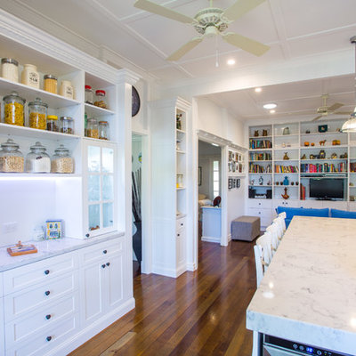 Eat-in kitchen - large traditional galley dark wood floor eat-in kitchen idea in Brisbane with shaker cabinets, white cabinets, white backsplash, colored appliances, an island, a farmhouse sink, solid surface countertops and subway tile backsplash