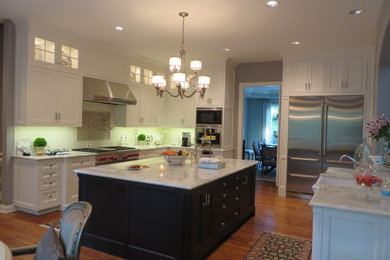 Elegant u-shaped eat-in kitchen photo in Chicago with a farmhouse sink, recessed-panel cabinets, white cabinets, yellow backsplash, subway tile backsplash and stainless steel appliances