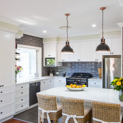 Example of a large classic l-shaped ceramic tile and gray floor open concept kitchen design in Brisbane with an undermount sink, shaker cabinets, white cabinets, quartz countertops, gray backsplash, subway tile backsplash, black appliances and an island