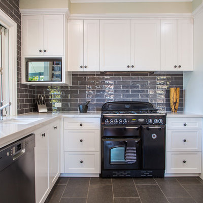 Open concept kitchen - large traditional l-shaped ceramic tile and gray floor open concept kitchen idea in Brisbane with an undermount sink, shaker cabinets, white cabinets, quartz countertops, gray backsplash, subway tile backsplash, black appliances and an island