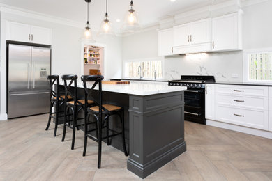 Inspiration for a large nautical open plan kitchen in Brisbane with shaker cabinets, white cabinets, granite worktops, black appliances, an island, stone slab splashback and ceramic flooring.