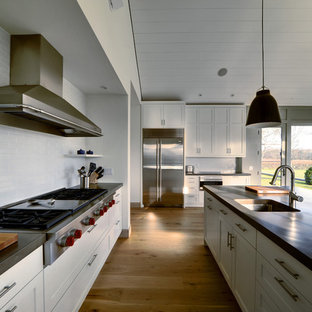Country kitchen in New York with stainless steel appliances and concrete benchtops.