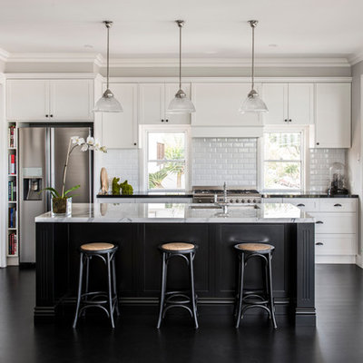 Inspiration for a transitional galley black floor open concept kitchen remodel in Brisbane with an undermount sink, shaker cabinets, white cabinets, white backsplash, subway tile backsplash, stainless steel appliances and an island