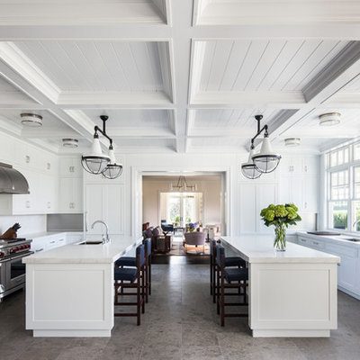 Huge elegant galley gray floor and porcelain tile enclosed kitchen photo in New York with an undermount sink, shaker cabinets, white cabinets, white backsplash, stainless steel appliances, two islands, marble countertops and stone slab backsplash