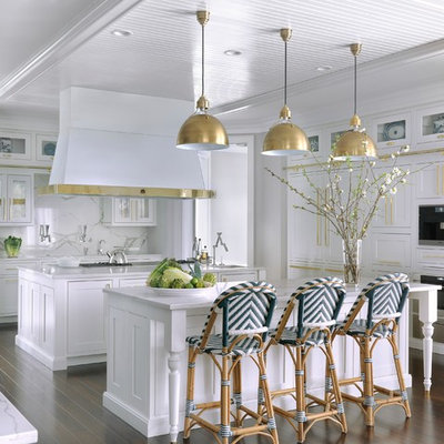 Large elegant u-shaped dark wood floor and brown floor kitchen photo in St Louis with marble countertops, marble backsplash, two islands, shaker cabinets, white cabinets, white backsplash and paneled appliances